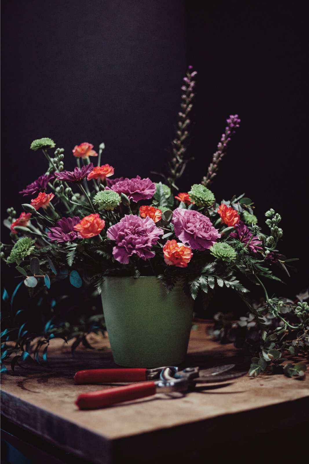 Mixed pink carnations and orange flowers on a wooden workbench at Butler's Florist in Ottawa, Kansas