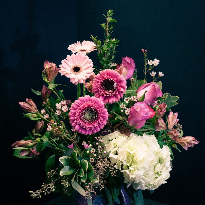 Pink gerberas and white hydrangea in a purple glazed vase